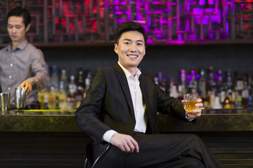 Young man having a drink at bar