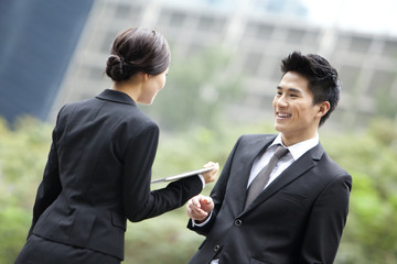 Cheerful business colleagues chatting with digital tablet in hand, Hong Kong
