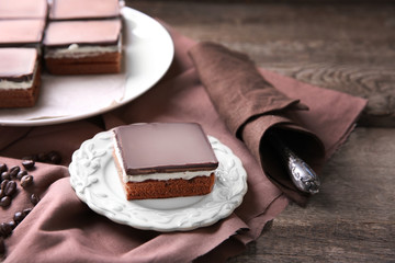 Delicious chocolate brownies on plate, on wooden background