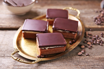 Delicious chocolate brownies on tray, on wooden background