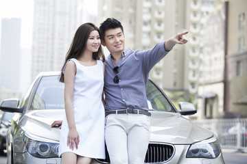 Happy young couple and car