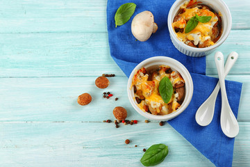 French dish julienne. Mushroom, chicken and cheese gratin in ceramic bowls, on wooden background