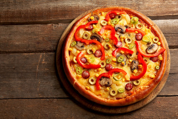 Delicious pizza on wooden background