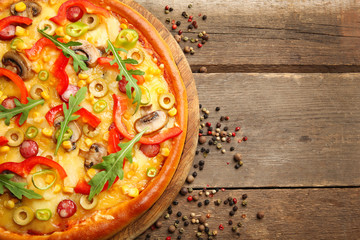 Delicious pizza with pepper on wooden background