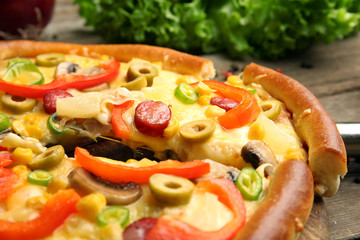Delicious pizza with vegetables and slice on shovel, close-up