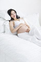 Obraz premium Pregnant woman resting in bed