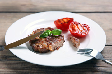 Roasted beef fillet on plate, on wooden background