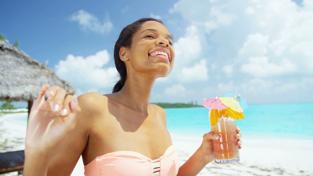 Happy young African American girl enjoying party cocktail on beach