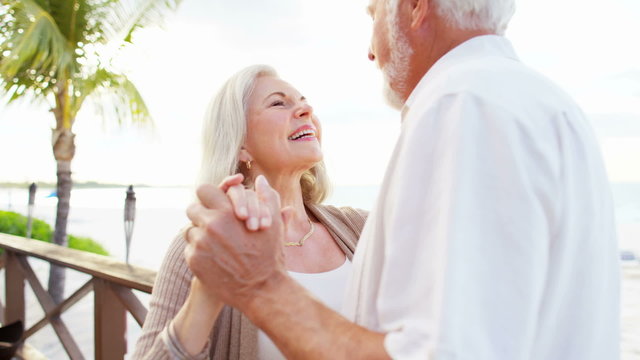 Mature Caucasian couple dancing on a tropical vacation 