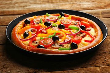 Delicious pizza with vegetables, on wooden table, close-up
