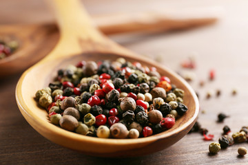 Pepper in wooden spoon on the table, close-up