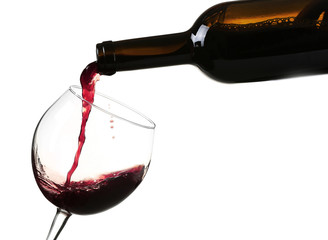 Red wine pouring in glass, isolated on white