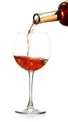 Rose wine pouring in glass, isolated on white