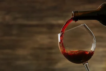 Fotobehang Red wine pouring in a glass © Africa Studio