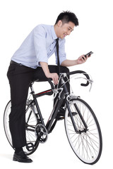 Fototapeta na wymiar Young businessman checking smart phone on bike