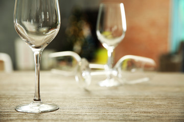 Empty wine glasses on wooden table against blurred background
