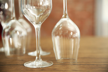 Construction of empty wine glasses on wooden table against blurred background