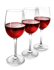 Three glasses of red wine on light background