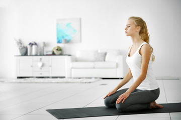 Young attractive woman do yoga exercise in the room