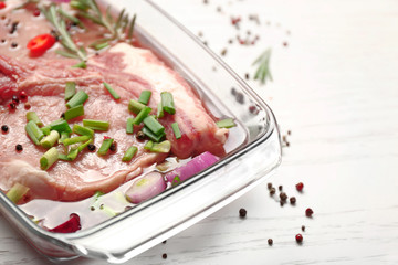 Marinating meat with spices on table, close up