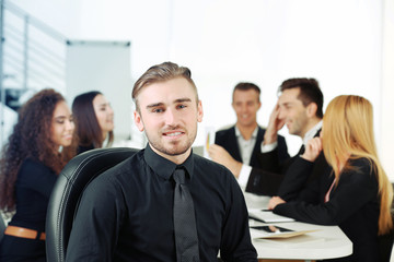 Obraz premium Photo of a young business man with his staff at the meeting in a conference room