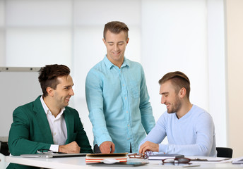 Obraz premium Three young business men at the meeting in a conference room