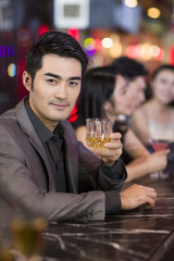 Young man drinking alcohol in bar