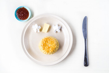 Simple plain English scones set with butter, cream, strawberry jam