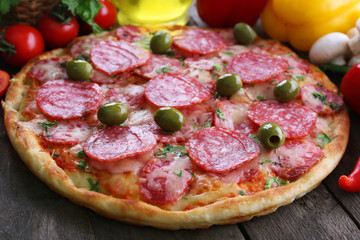 Delicious tasty pizza with ingredients on table, closeup