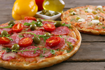 Delicious tasty pizzas with ingredients on table, closeup