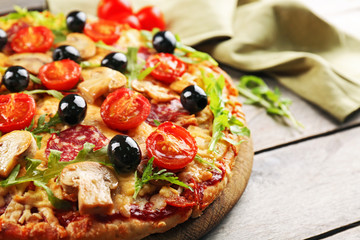 Delicious tasty pizza with ingredients on wooden table