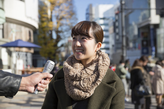 街頭インタビューを受ける若い女性　街中雑踏　東京原宿表参道