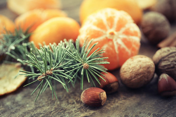 Beautiful still life with tangerines and fir-tree, on old wooden table, close up