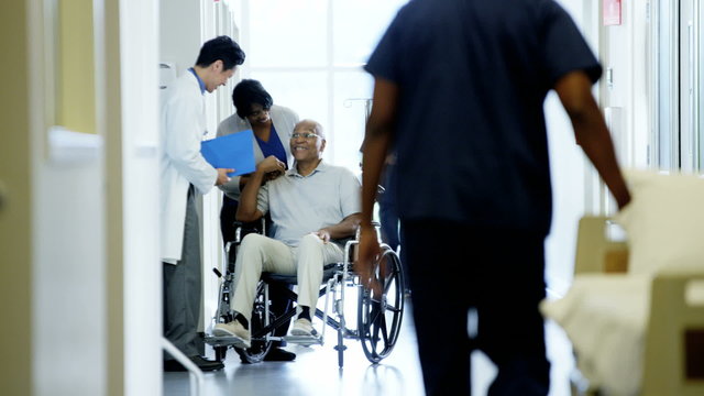 African American disabled male on wheelchair and wife in medical center