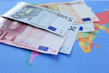 Different euro banknotes on a map background