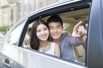 Naklejka premium Happy young couple in a car