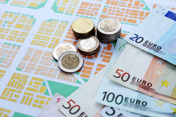 Euro coins and banknotes on map background