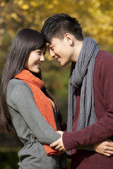 Sweet young couple in love face to face outdoors in autumn