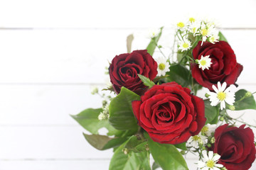 red roses on the white wooden background