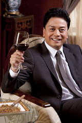 Mature businessman enjoying wine in a luxurious room
