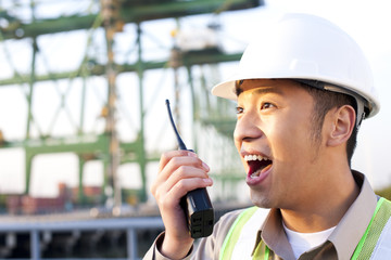 shipping industry worker using a walkie-talkie talking