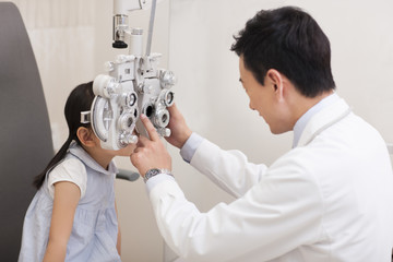 Doctor examining girl's eyes