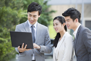 Young business person working with laptop outdoors