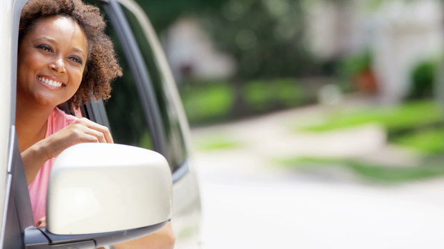 Portrait of young happy African American female driving new car