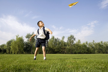 Boy playing with a paper airplane