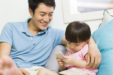 Happy father and daughter with smart phone