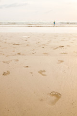 footprints on the beach at sunset time