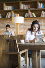 Young woman using digital tablet in cafe