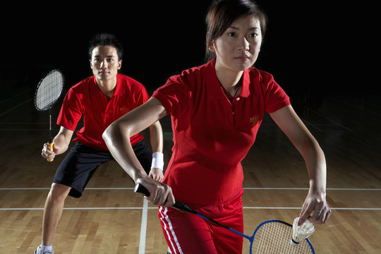 Young Man And Woman Preparing To Return A Badminton Shot