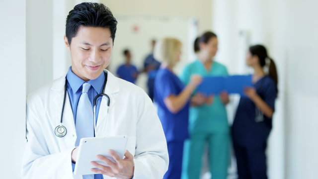 Asian American male young doctor working on tablet technology in medical centre